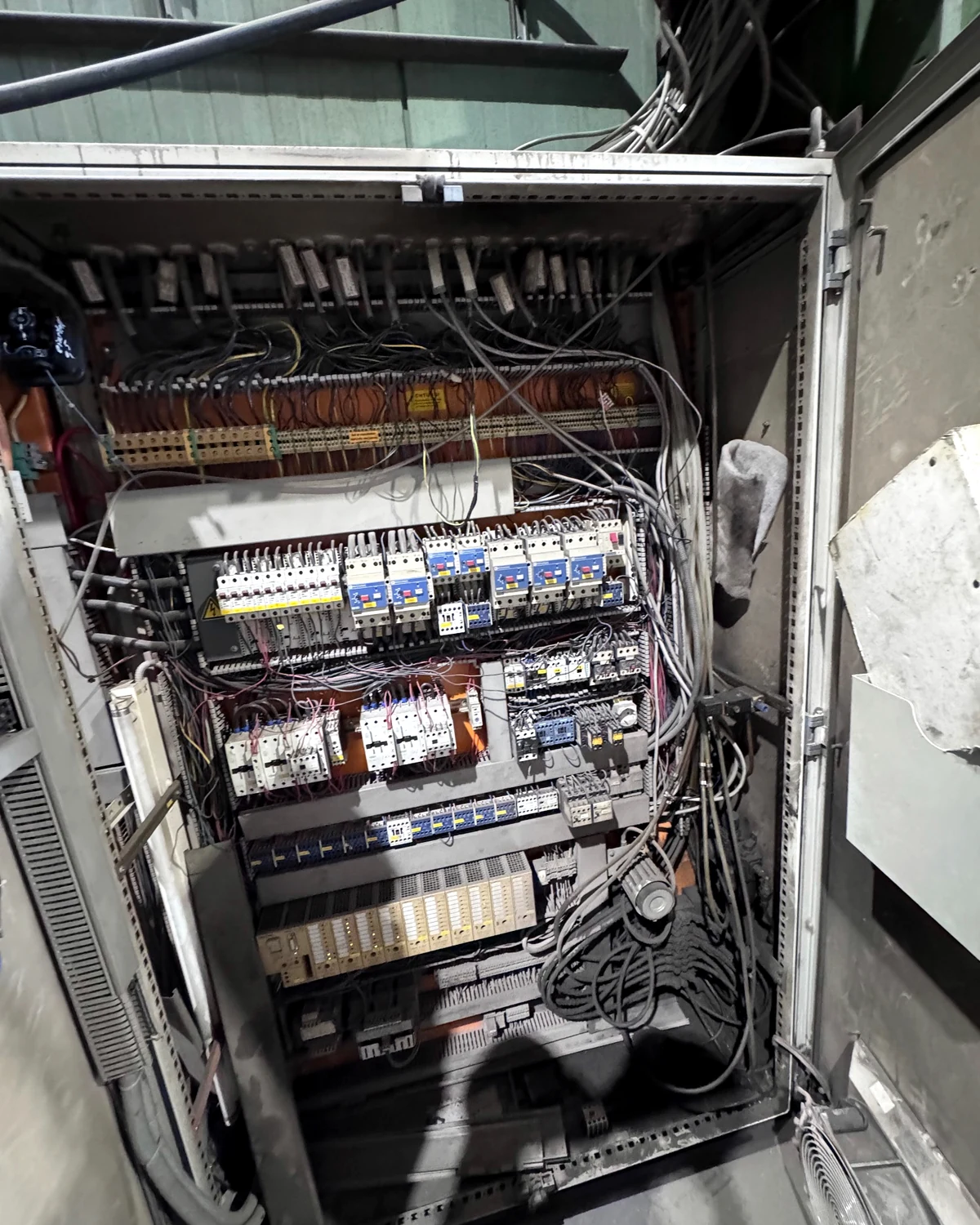 Geöffneter Bestands-Schaltschrank einer Maschine vor dem SPS-Retrofit und der technischen Bestandsaufnahme