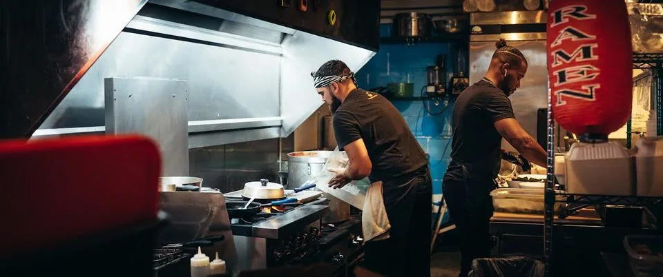 Köche arbeiten in einer Gastronomie-Großküche – hoher Energieverbrauch durch Herd, Lüftung und Kühlung